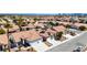 A desert neighborhood featuring homes with tile roofs, two car garages, desert landscaping, and solar panels in the distance at 7404 Dry Corral Ln, Las Vegas, NV 89113