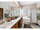 Bathroom featuring dual sinks, vanity, a bathtub, and a glass-enclosed shower at 7404 Dry Corral Ln, Las Vegas, NV 89113