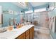 Bright bathroom featuring dual sinks, vanity, a bathtub, and a glass-enclosed shower at 7404 Dry Corral Ln, Las Vegas, NV 89113