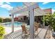 View of a cozy outdoor patio with pergola cover, seating, and pool view at 7404 Dry Corral Ln, Las Vegas, NV 89113