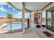 View of a sparkling pool with patio, covered seating area, and safety fence, perfect for outdoor relaxation and entertaining at 7404 Dry Corral Ln, Las Vegas, NV 89113