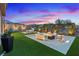 Backyard with fire pit feature, lounge seating, and landscaped lawn, ideal for outdoor gatherings at 754 Spirit Lake St, Las Vegas, NV 89138