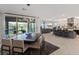 Open concept dining area with large table, contemporary lighting, and views of the backyard and living spaces at 754 Spirit Lake St, Las Vegas, NV 89138