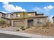 Stylish home boasts a stone facade, a well-maintained front yard, and a convenient two-car garage at 754 Spirit Lake St, Las Vegas, NV 89138