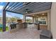 Outdoor kitchen featuring a built-in grill, bar seating, and a covered patio area for entertaining at 754 Spirit Lake St, Las Vegas, NV 89138