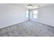 A carpeted bedroom with two windows and a modern ceiling fan at 756 Sleeping City Ave, Henderson, NV 89015