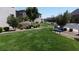 Expansive front yard featuring lush green lawn, mature trees, and a welcoming blue bench at 756 Sleeping City Ave, Henderson, NV 89015