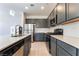 Close up of the kitchen featuring gray cabinetry, stainless steel appliances, and a stylish herringbone backsplash at 756 Sleeping City Ave, Henderson, NV 89015