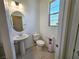Bright powder room featuring a pedestal sink, toilet, and window offering natural light at 756 Sleeping City Ave, Henderson, NV 89015