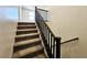 Carpeted staircase with a dark wood railing leading to the upper level of the home at 756 Sleeping City Ave, Henderson, NV 89015