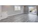 Bedroom featuring wood floors, a window with shutters, and an open door to backyard at 7575 Coley Ave, Las Vegas, NV 89117