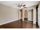 Bedroom with dark floors, ceiling fan, closet with mirrored doors, and a view into a closet at 7575 Coley Ave, Las Vegas, NV 89117