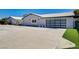 Modern house with large windows, glass garage door, and manicured landscaping on a sunny day at 7575 Coley Ave, Las Vegas, NV 89117
