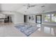 Bright living room with gray walls, tile floors, modern ceiling fan, and large windows overlooking the backyard at 7575 Coley Ave, Las Vegas, NV 89117