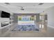 Open-concept living room featuring tile floors, modern fireplace, ceiling fan, and sliding doors to the pool at 7575 Coley Ave, Las Vegas, NV 89117