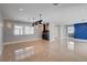 Open living room with tile floors, windows, bar and custom art piece at 7575 Coley Ave, Las Vegas, NV 89117