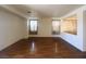 Open living area featuring hardwood floors, neutral paint, and large windows with decorative curtains at 7611 Avila Beach Ave, Las Vegas, NV 89113