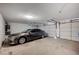 Garage with gray car parked inside featuring a door and light fixtures at 7898 Rye Canyon Dr, Las Vegas, NV 89123
