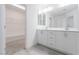 Bright bathroom with dual sinks, white cabinets, and walk-in closet entrance at 8125 Monsoon Bay St, Las Vegas, NV 89113