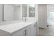 Bathroom with double vanity and white countertops, complemented by light wood-look flooring at 8125 Monsoon Bay St, Las Vegas, NV 89113