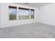 Bright, carpeted bedroom with large windows that offer an expansive view at 8125 Monsoon Bay St, Las Vegas, NV 89113