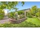 Serene backyard garden with manicured landscaping, a colorful flower bed, and lush green grass at 8732 Kendall Brook Cir, Las Vegas, NV 89149