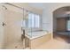 Elegant bathroom featuring a walk-in shower and a soaking tub at 8732 Kendall Brook Cir, Las Vegas, NV 89149
