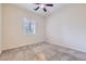 This bedroom features neutral walls and carpet, bright natural light, and a ceiling fan for added comfort at 8732 Kendall Brook Cir, Las Vegas, NV 89149