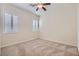 Bright bedroom with neutral carpet, two shuttered windows, and a ceiling fan at 8732 Kendall Brook Cir, Las Vegas, NV 89149