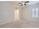 Neutral-toned carpeted bedroom with ceiling fan, plantation shutters, and interior door at 8732 Kendall Brook Cir, Las Vegas, NV 89149