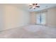 Spacious carpeted bedroom with a ceiling fan and glass patio doors to let in natural light at 8732 Kendall Brook Cir, Las Vegas, NV 89149