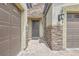 Exterior of a home featuring stone accents, a front door, and a two-car garage at 8732 Kendall Brook Cir, Las Vegas, NV 89149