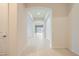 Bright hallway featuring tile flooring and an arched entryway to the living room and kitchen areas at 8732 Kendall Brook Cir, Las Vegas, NV 89149