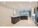 Bright kitchen featuring an island with granite countertop and dark brown cabinets, stainless steel appliances, and tile flooring at 8732 Kendall Brook Cir, Las Vegas, NV 89149