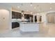 Bright kitchen featuring an island with granite countertop and dark brown cabinets, stainless steel appliances, and tile flooring at 8732 Kendall Brook Cir, Las Vegas, NV 89149