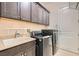 Convenient laundry room featuring modern appliances, a utility sink, and ample cabinet space for storage at 8732 Kendall Brook Cir, Las Vegas, NV 89149