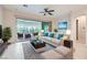 Bright living room with stylish furnishings, a ceiling fan, and a sliding glass door to the sunroom at 8732 Kendall Brook Cir, Las Vegas, NV 89149