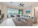 Bright living room with stylish furnishings, a ceiling fan, and a sliding glass door to the sunroom at 8732 Kendall Brook Cir, Las Vegas, NV 89149