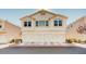 Traditional townhome featuring an attached garage, neutral stucco exterior, and well-maintained landscaping at 8811 Tomnitz Ave # 101, Las Vegas, NV 89178