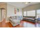 Spacious living room with vaulted ceilings, large windows, wood floors, and a comfortable sectional couch at 8811 Tomnitz Ave # 101, Las Vegas, NV 89178