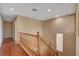Hallway featuring wood floors, neutral walls, and a wooden railing staircase leading to the next level at 8988 Winchester Ridge St, Las Vegas, NV 89139