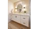 Bathroom vanity with drawers, cabinets, modern fixtures, and a unique mirror at 901 Sir Winston St, Henderson, NV 89052