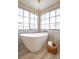 Modern bathroom featuring a freestanding tub, large windows, and stylish light fixture at 901 Sir Winston St, Henderson, NV 89052