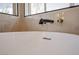Close up of a soaking tub with designer fixtures and large windows at 901 Sir Winston St, Henderson, NV 89052