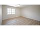 An empty light and bright bedroom with wood floors and one window at 901 Sir Winston St, Henderson, NV 89052
