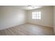 An empty light and bright bedroom with wood floors and one window at 901 Sir Winston St, Henderson, NV 89052
