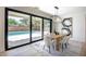 Bright dining room features a modern light fixture, sliding glass doors, and a view of the pool at 901 Sir Winston St, Henderson, NV 89052