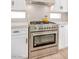 Stainless steel range with white cabinets and tile backsplash makes for a modern gourmet kitchen at 901 Sir Winston St, Henderson, NV 89052