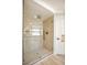 Modern glass shower with floor to ceiling marble look tile, a gold shower head and fixtures at 901 Sir Winston St, Henderson, NV 89052