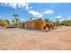 Wide shot of yard with large desert area, single story building, and palm trees at 912 Santa Ynez Ave, Henderson, NV 89002